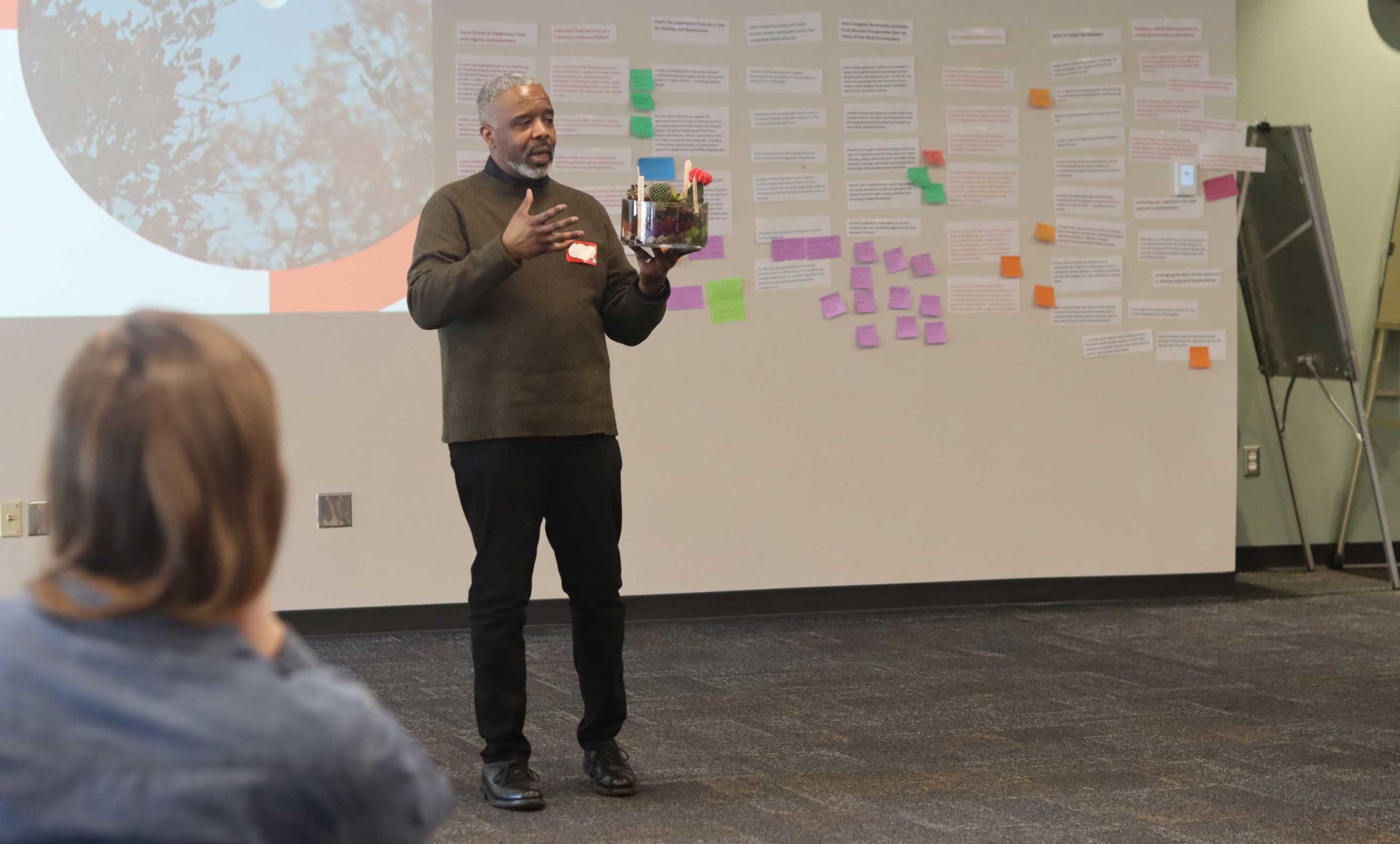 Person leading discussion while holding terrarium